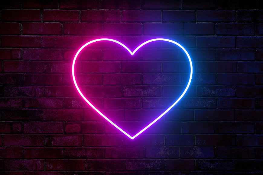 Photo of neon heart on brick wall