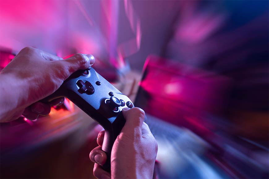 Photo of a person holding a game controller with a motion blur on the background