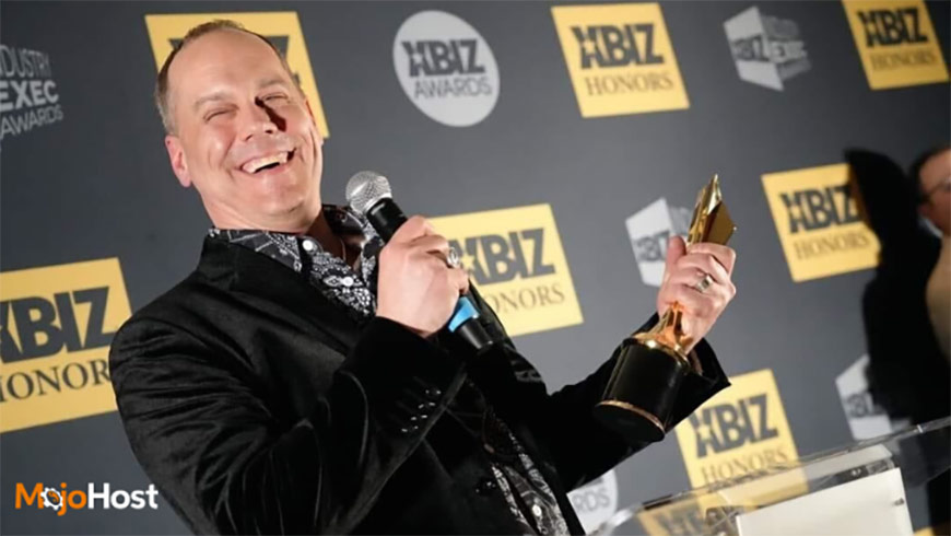 Photo of Brad Mitchell holding an XBIZ award